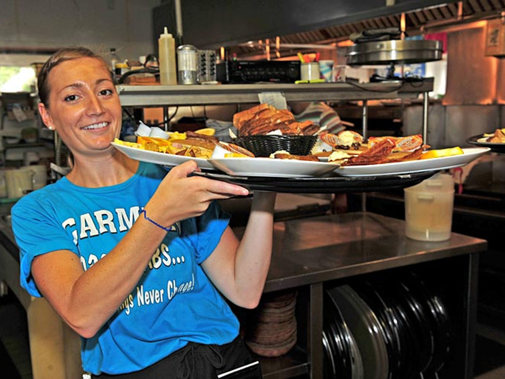 A Carmen's server bringing out a seafood platter