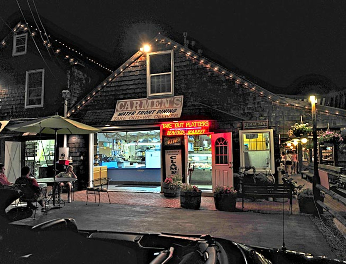 Carmen's storefront lit up at night